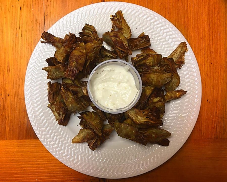 A plate of crispy baby artichokes served with labneh and sumac dip.
