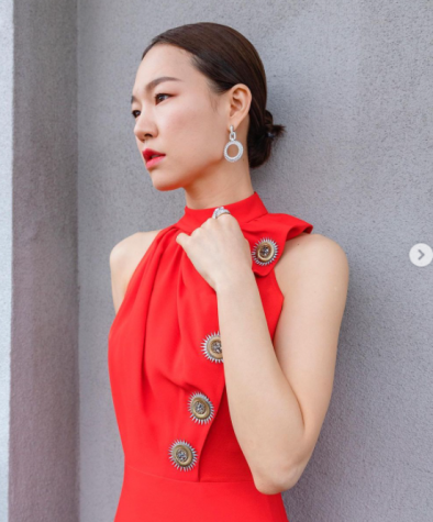 The "Minari" star Han Ye-ri poses in a red Louis Vuitton dress with golden suns down her left side to her waist.