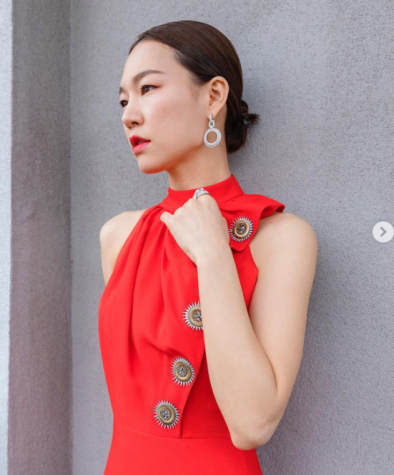 The "Minari" star Han Ye-ri poses in a red Louis Vuitton dress with golden suns down her left side to her waist. 