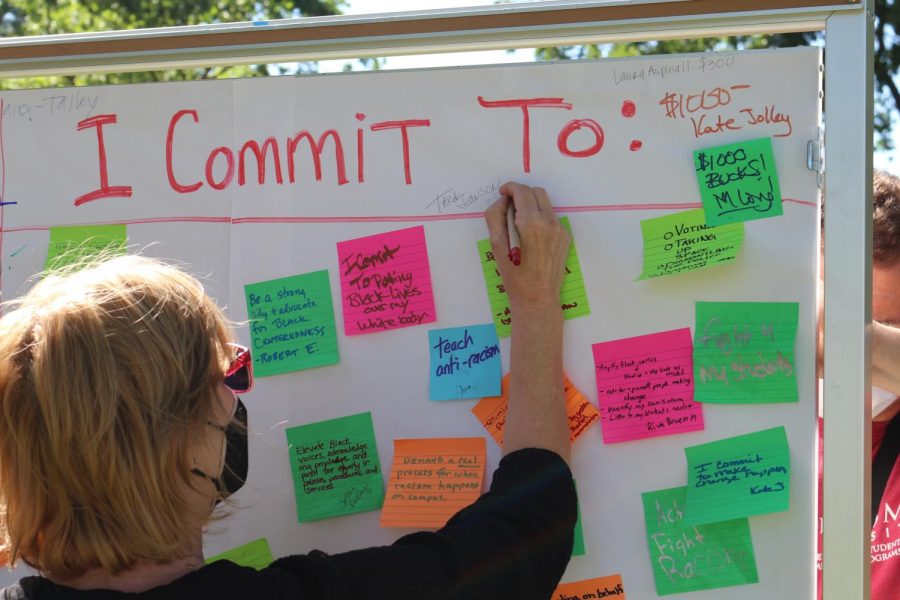 Participant writes a pledge amount to fund a Black student success center among other participants' commitments to end systemic racism at SRJC.