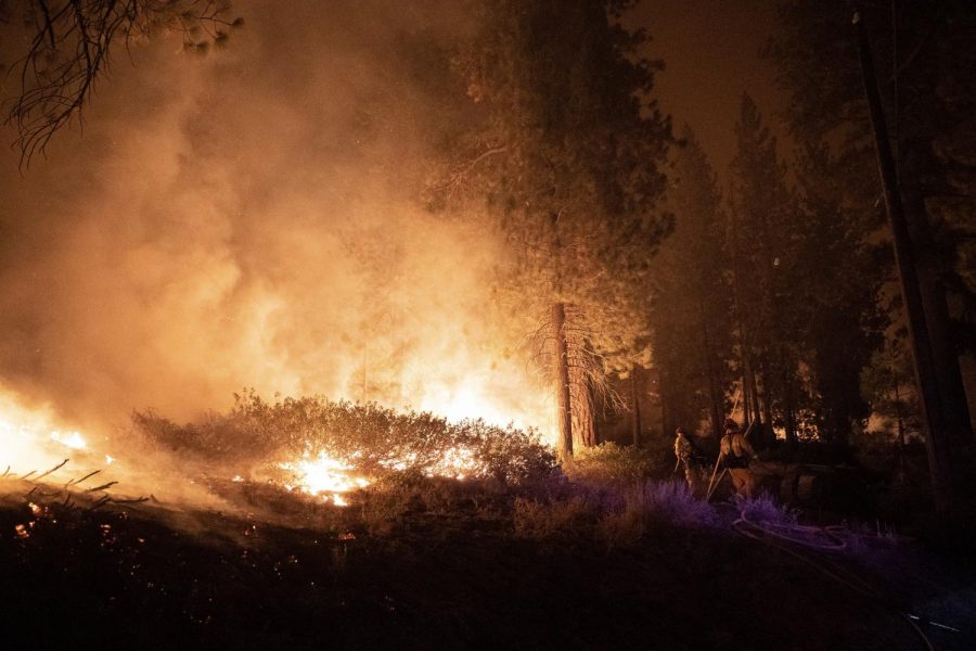 Firefighters work to extinguish the Caldor Fire early Tuesday morning in the Tahoe Paradise area off of Highway 50.