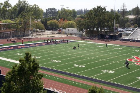 An overhead view shows football players practicing on a new football field.