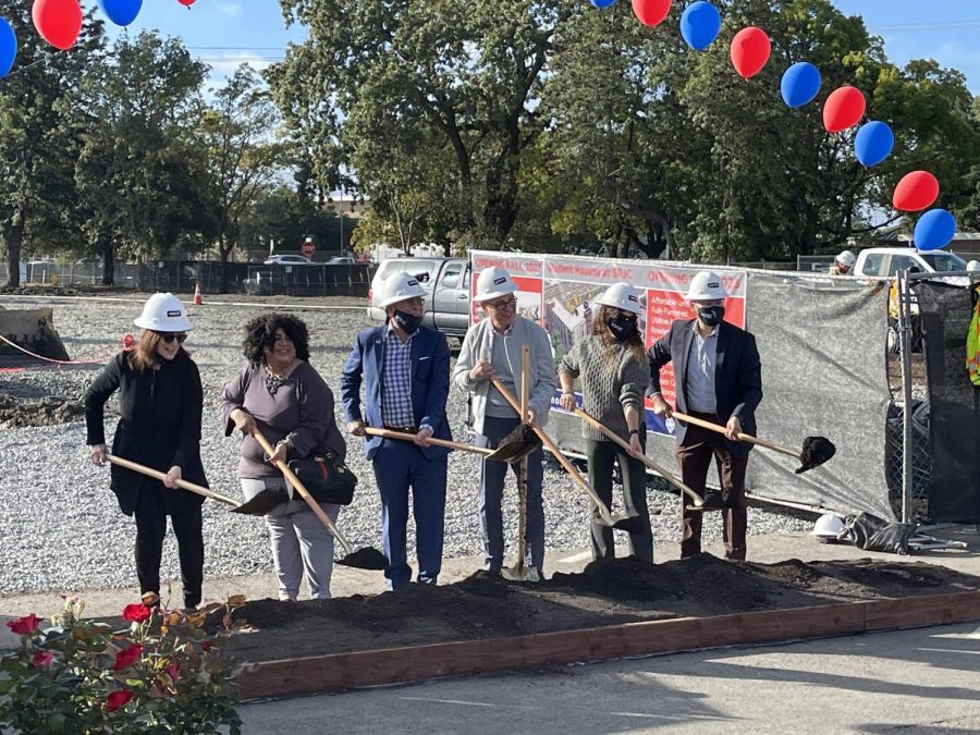 Six people standing with shovels during the groundbreaking ceremony for new on-campus housing.