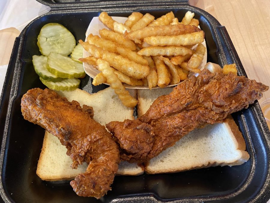 Chicken, bread, pickles and fries in a takeout container.
