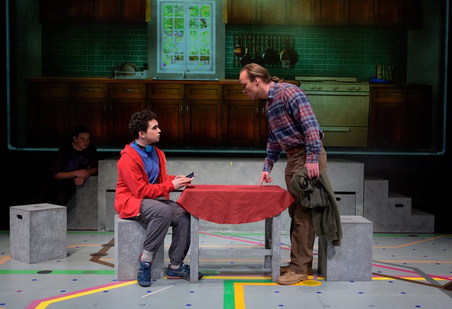A standing man talks to a boy who is sat at a table during the SRJC Theatre Arts performance of "The Curious Incident of the Dog in the Nighttime."