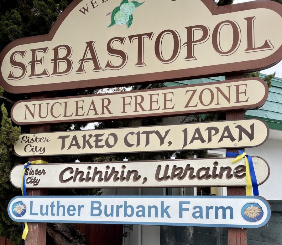 A beige and brown sign reads Welcome to Sebastopol and features blue and yellow ribbons next to Chihirin, Ukraine, one of Sebastopols two sister cities.