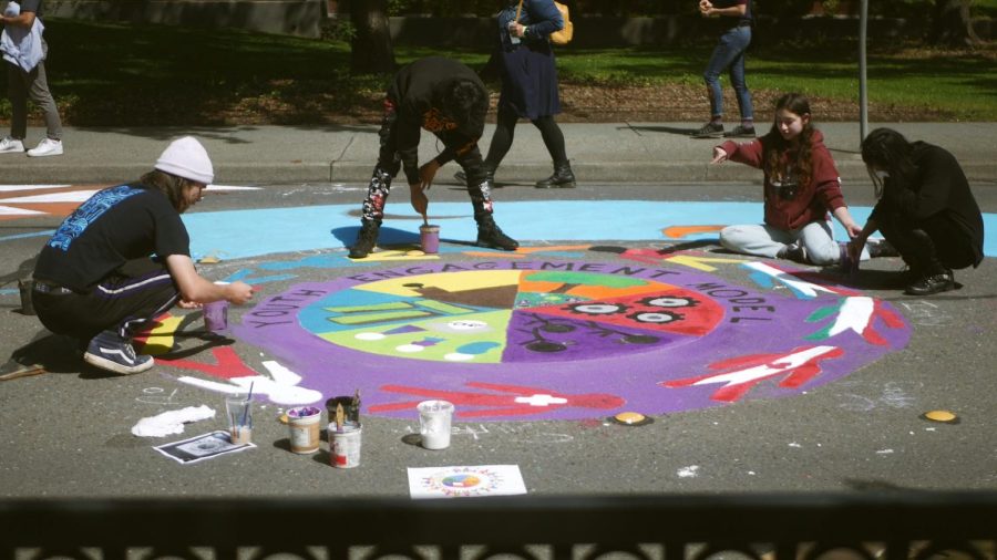 Painters finishing their design for their Youth Engagement Model mural created   on Earth Day