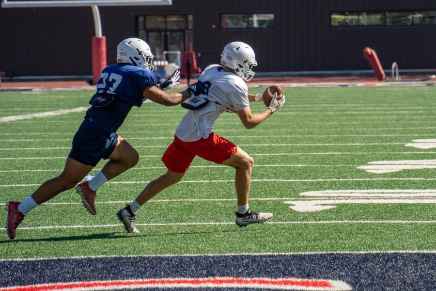 The ball carrier attempts to outrun the defender, while his jersey is being pulled on Aug. 26 at Bailey Field.