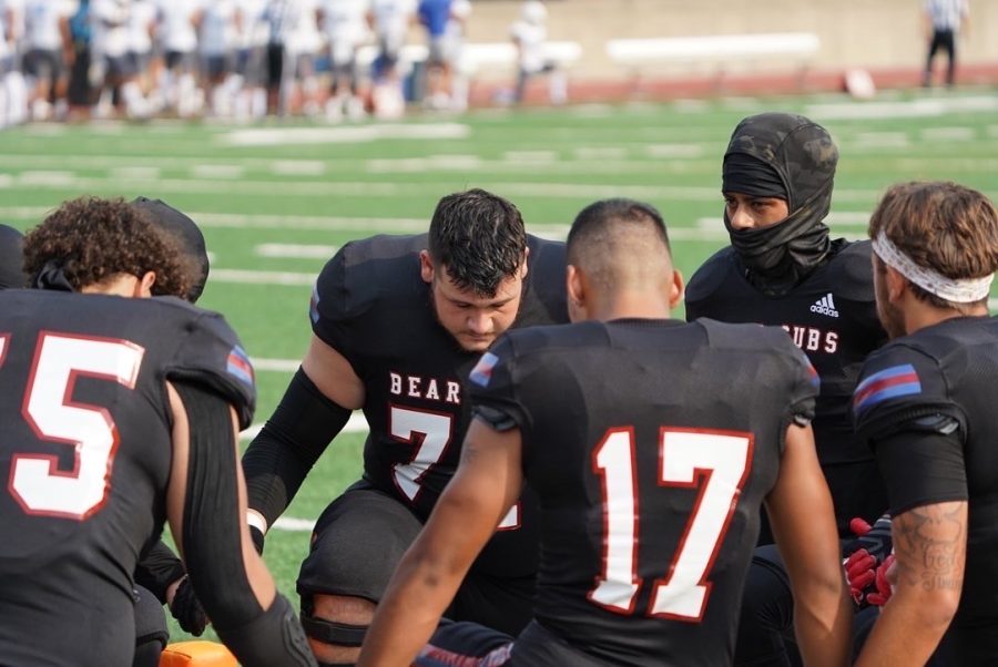 A few Bear Cubs kneel for a prayer minutes before the kickoff of their matchup against Modesto Sept. 10.