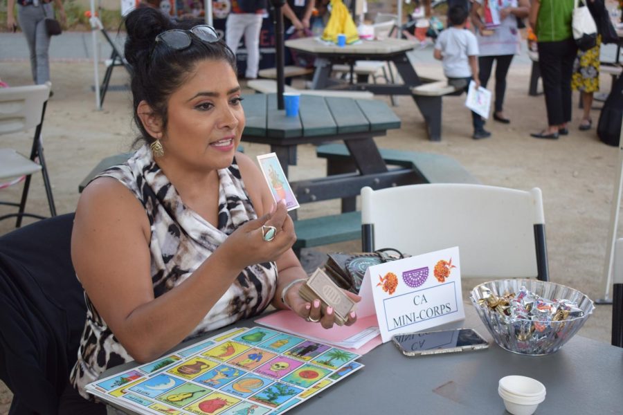 Irma Román hosts a game of Loteria, a game of chance similar to bingo, at SRJC's Dia de los Muertos procession and celebration.