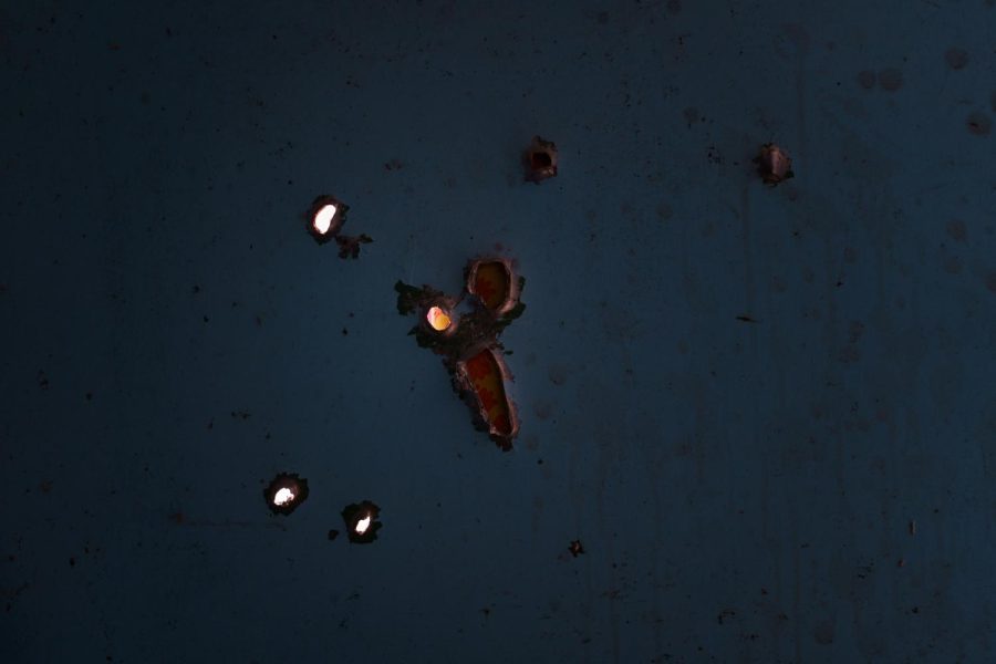 Holes left by artillery shrapnel in a steel door to a shelter, utilized by a family of six during Russian occupation, in Malaya Rohan on Aug. 10, 2022.