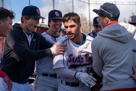 Bear Cubs outfielder Michael O’Daniel is met with a crowd of his teammates after hitting a three-run shot in the bottom of the fourth inning against Consumnes River College on Tuesday, March 7, 2023 in Santa Rosa.