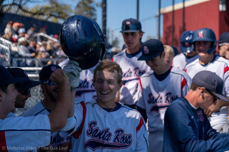 Bear Cubs infielder/pitcher Aidan Lombardi is met with a crowd of teammates after hitting a home run in the bottom of the first against American River College on Tuesday, April 4, 2023 in Santa Rosa. 