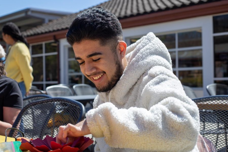 Adrian Arango glues a paper flower together. They said the experience was calming. 