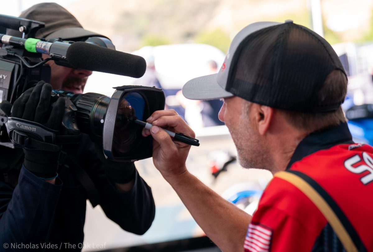 Pro Stock Motorcycle driver Matt Smith signs the FOX camera during a driver signing event at Sonoma Raceway on Saturday, July 29, 2023 in Sonoma.