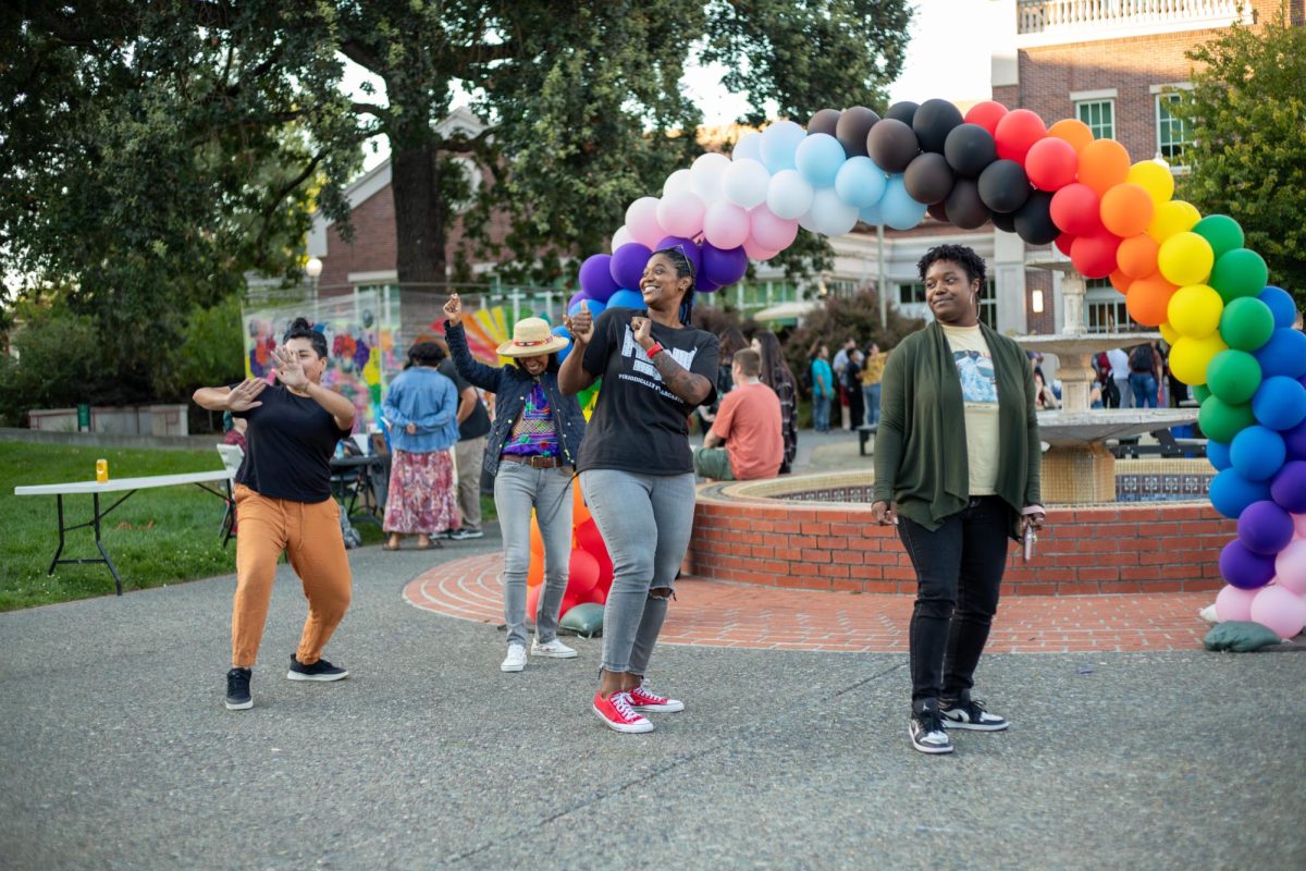 A small group does a choreographed dance to V.I.C.’s “Wobble Baby” at the Queer Resource Center Rainbow Welcome Dinner on Sept. 26. From left to right: Laura LeCave of Positive Images, Isabel Lopez of Raizes Collective, Regina Mahiri of Black Student Support Center and D’yonna Johnson of Black Student Union and UMOJA. 