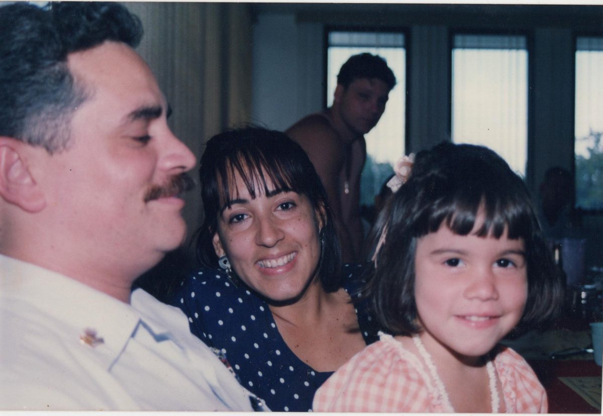 Leilany Sosa sits on her dad Wilfredo's lap next to her mom Lourdes at a party at a friend's home.