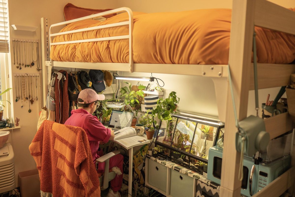 SRJC student and Resident Advisor for SRJC's Polly O'Meara Doyle dormitory Jayce Kaldunski maximizes space in his room with a couch and study area surrounded by his carnivorous plant collection under a bunk bed. 
