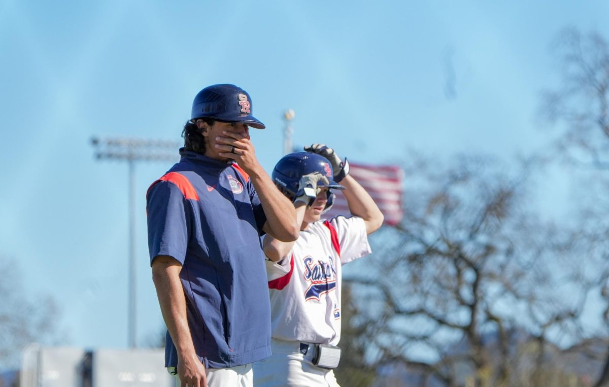 Right fielder Quinn Medin and third base coach Jeff Bart look on incredulously as the Bear Cubs continue their descent in the bottom of the eighth inning against Diablo Valley College at Santa Rosa’s Cook Sypher Field, Thursday, March 14, 2024.