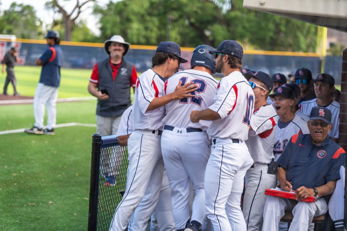 Zane Bennett is met at the top of the dugout by Jordan Giacomini and Michael O'Daniel as they praise Bennett's solo home run in the bottom of the fifth against American River College at Santa Rosa's Cook Sypher Field on Thursday, April 25, 2024.