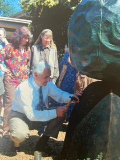 Former SRJC President Robert F. Arella starts the tradition of hammering tacks with a prayer for the Earth into local artist Bruce Johnson’s piece, “A Prayer For The Earth,” at its installation in 1999.