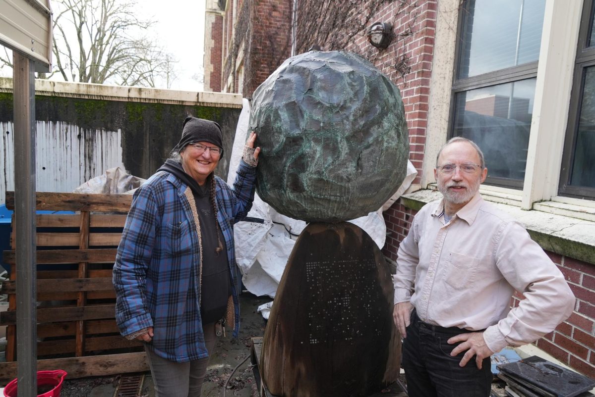 Michael McGinnis and Laura Bacon stand in Analy Hall with the local artist Bruce Johnson's world-renowned sculpture, "A Prayer For The Earth," which awaits restoration.  
