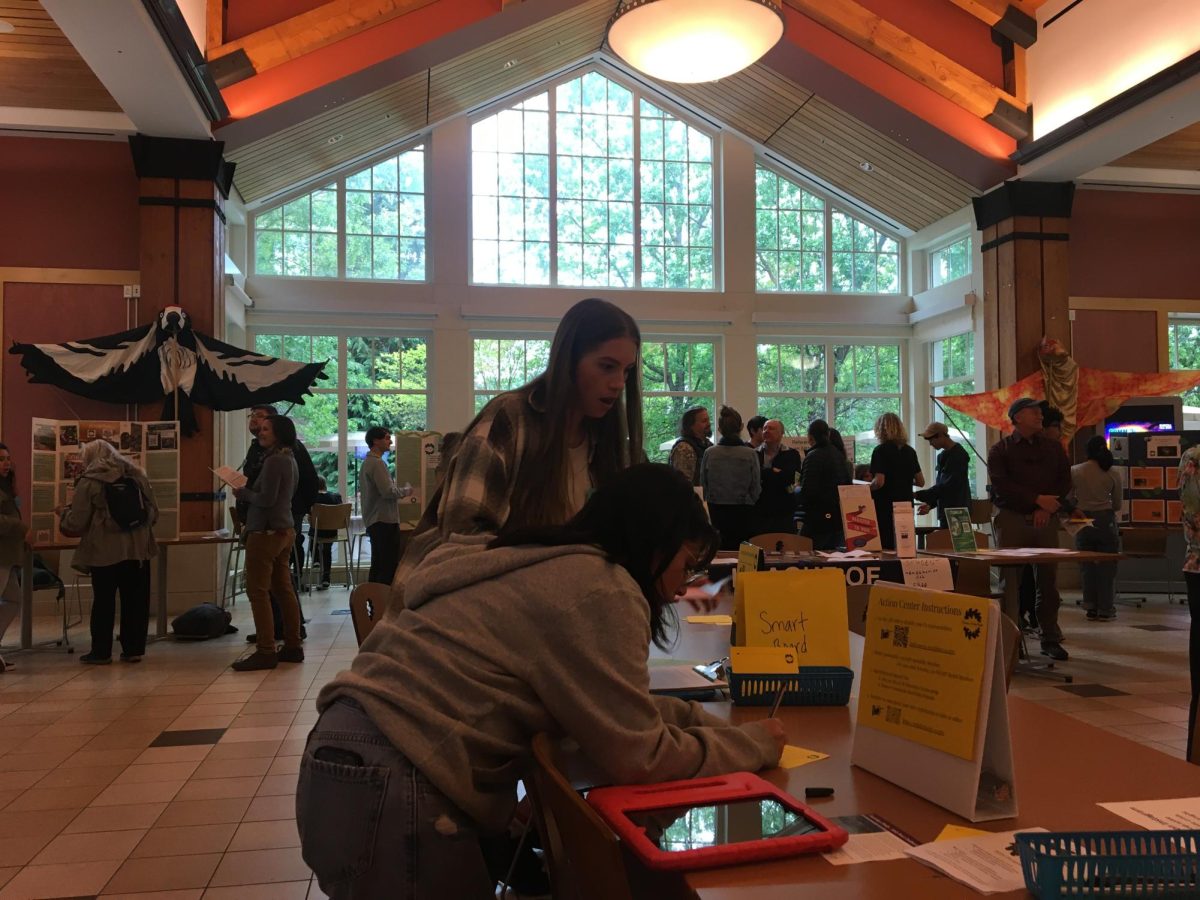 Climate Action Night Attendees fill out postcards to legislators advocating for climate-related bills at the Action Center set up in the center of the atrium on April 25, 2024. 