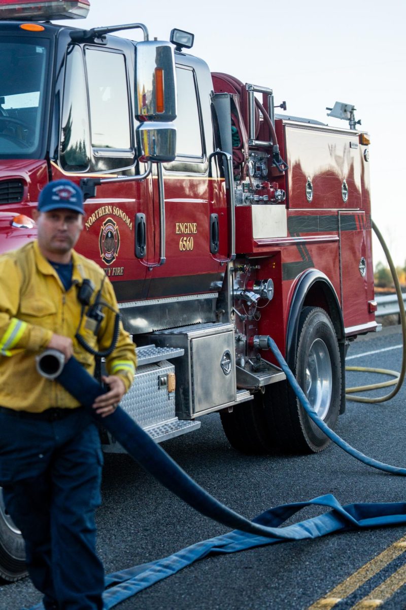 A crew member from Northern Sonoma County Fire cleans up on Skaggs Springs Road during the Point Fire on Sunday, June 16, 2024.