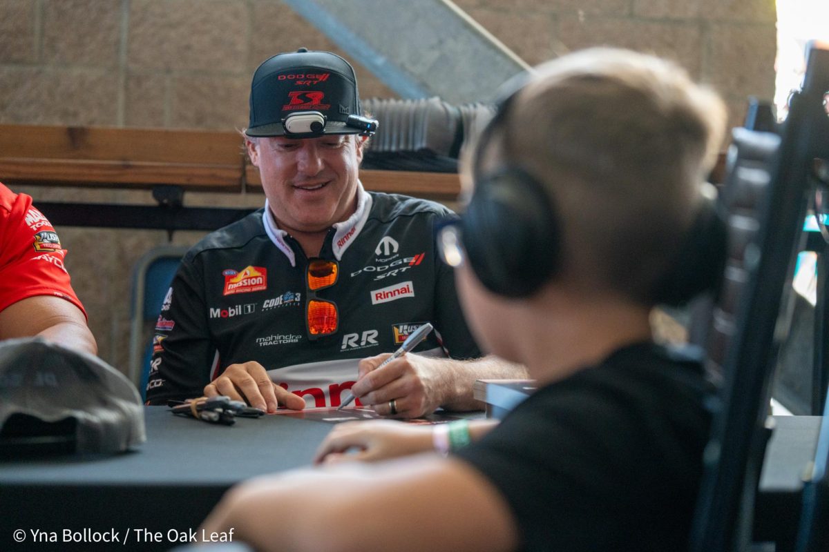 Top Fuel driver Tony "Smoke" Stewart autographs a sign for a fan at the DENSO NHRA Sonoma Nationals on Friday, July 26, 2024 in Sonoma.