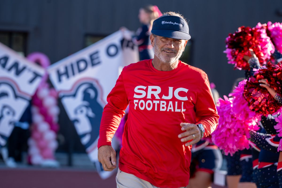 SRJC head coach Lenny Wagner runs out to the field ahead of the homecoming game honoring breast cancer awareness month against Butte College at home on Friday, Oct. 18, 2024.