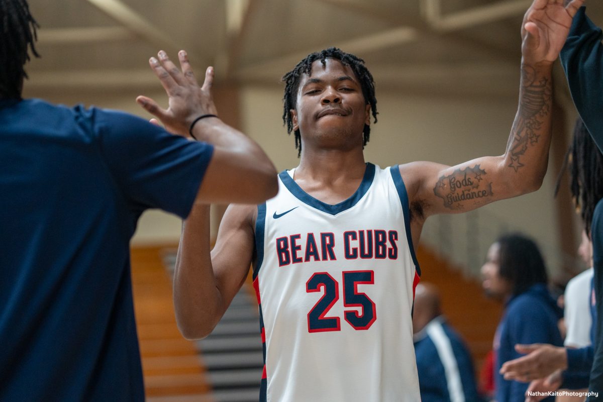 Santa Rosa's guard Gavin Cook-Whisenton walks through a wave of high-fives as announcer, Trey Dunia echoes his name around Haehl Pavilion on Tuesday, Jan. 14, 2025