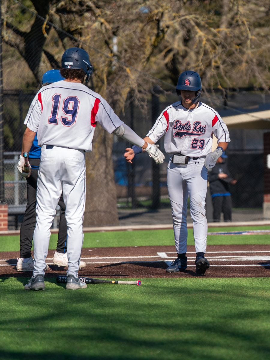 Santa Rosa third baseman Caze Derammelaere greets right fielder Cooper Wood at the plate after a single from catcher Cameron Duran brings him home in the bottom of the third at home against Modesto on Tuesday, Feb. 25, 2025.