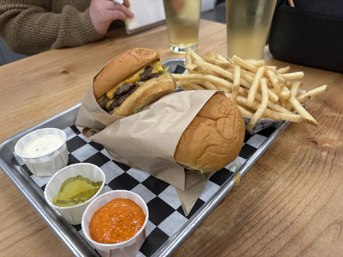 Cover: Cock Robin offers cost friendly burgers paired with fresh fries, pickles, ranch, and a romesco sauce. 
