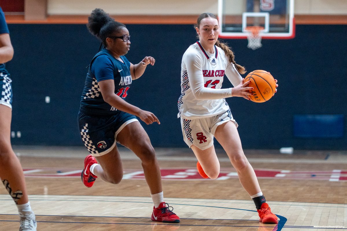 Bear Cubs' guard Caitlin Baldwin bursts into the paint and shields the ball from American River's guard, Aaliyah Jordan at Haehl Pavilion on Friday, Feb. 21, 2025.