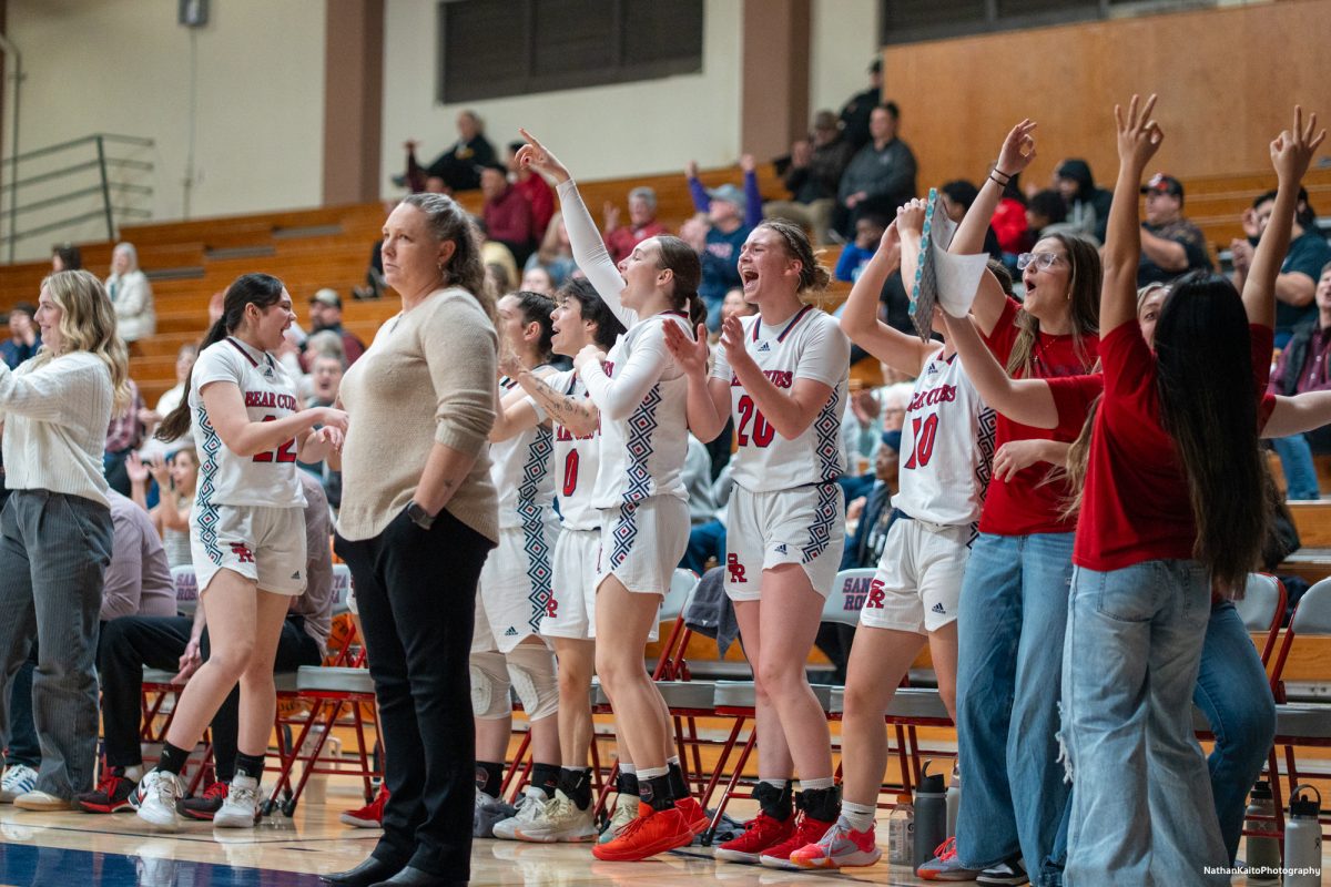 Bear Cubs' head coach Lacey Campbell looks on calmly while the bench celebrates  enthusiastically during a dominant performance against American River at Haehl Pavilion on Friday, Feb. 21, 2025.