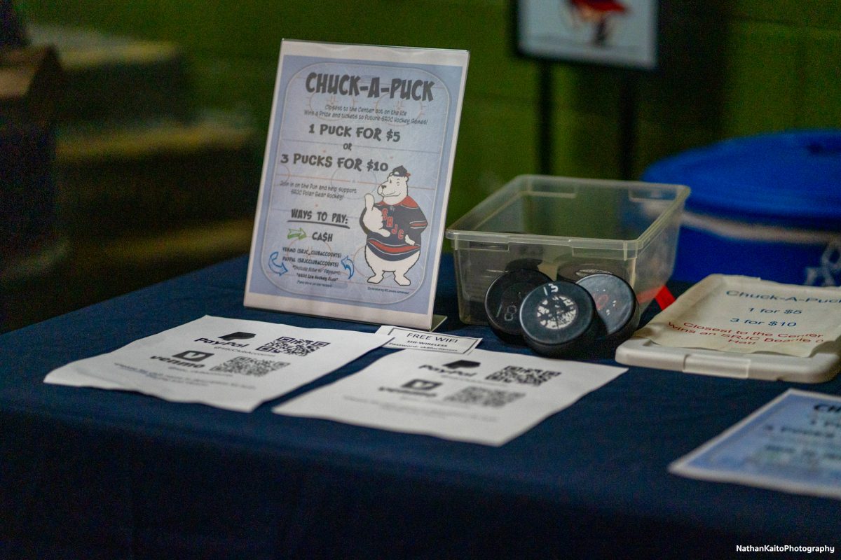 A table with sign-ups for the intermission's entertainment, "Chuck A Puck", sits by Snoopy Home Ice's entrance, where proceeds go towards funding SRJC's clubs.