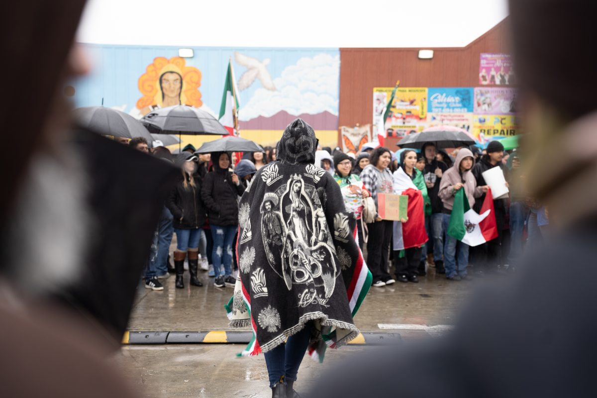 A protester wears a poncho with a picture of Our Lady of Guadalupe on the back outside of Mitote Food Park on Monday, Feb. 3, 2025.