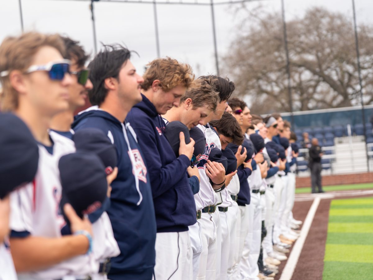Players from the SRJC baseball team stand at the first base path and pay their respects as the national anthem is played over the loudspeakers prior to the game against Lassen College at home, Sunday, Feb. 16, 2025.