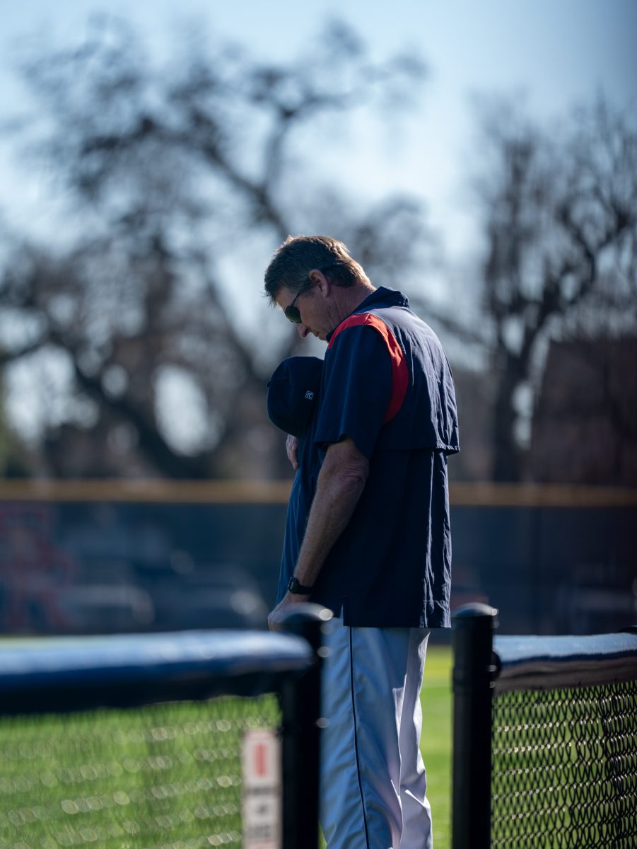 Baseball head coach Damon Neidlinger bows his head in solemnity as the national anthem is played prior to the game against West Valley College at home, Tuesday, Jan. 28, 2025.