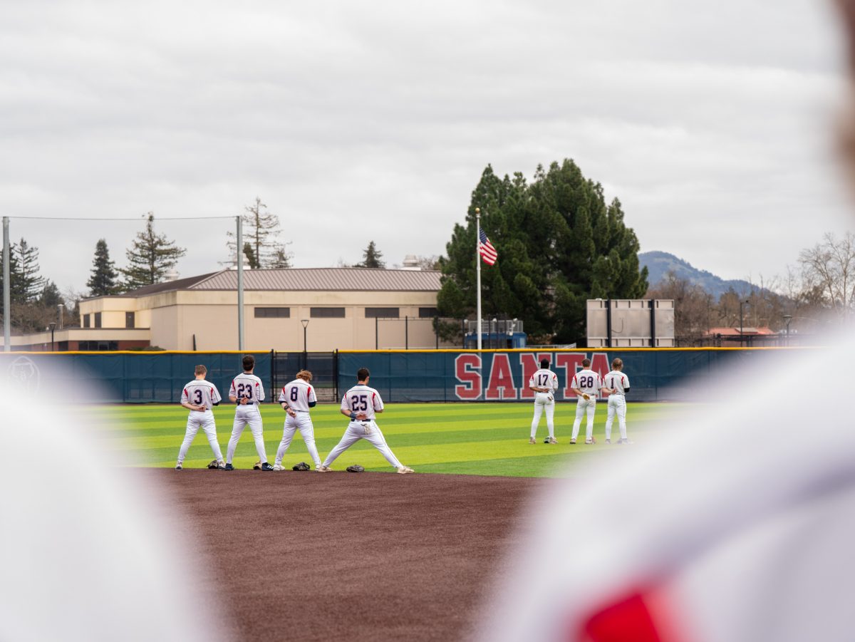 The SRJC baseball starting lineup face the flag for the national anthem, right hands to their hearts at center field, right before the game against Lassen College at home, Sunday, Feb. 16, 2025.