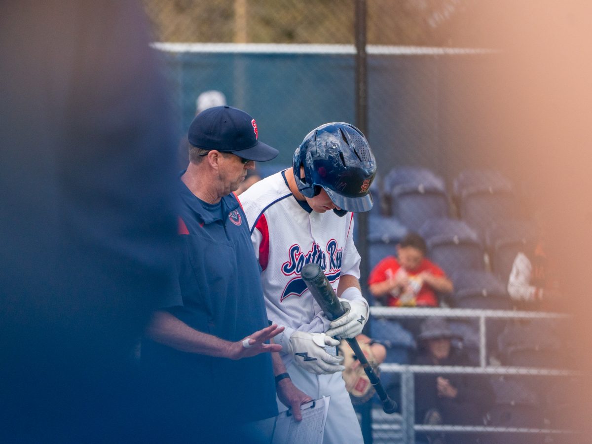 Head coach Damon Neidlinger strategizes with freshman Brett Neidlinger during his at-bat against San Joaquin Delta on Tuesday, March 11, 2025 in Santa Rosa.