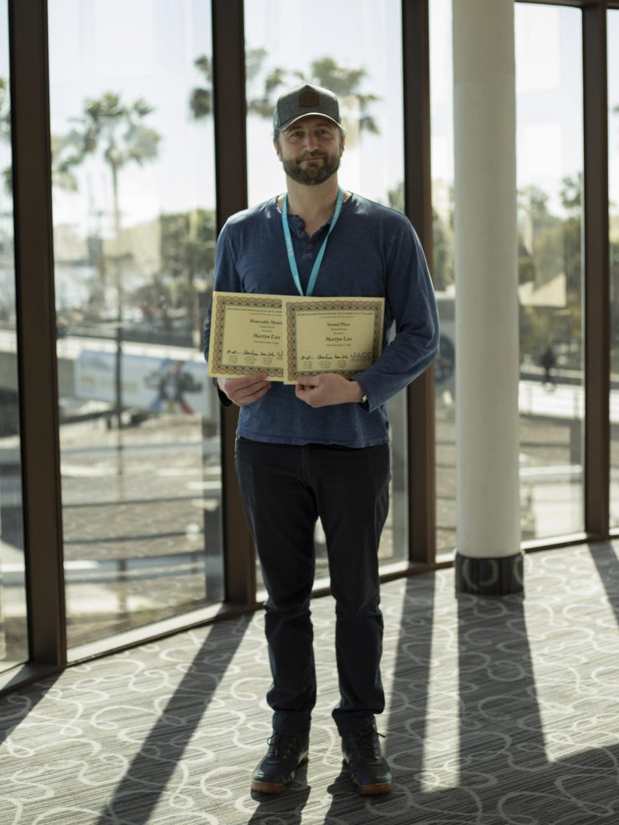 The Oak Leaf's reporter, Martyn Lees smiles proudly as he holds up his on the spot awards at the ACP Spring National Media Conference on Saturday, March 8, 2025 in Long Beach, California.