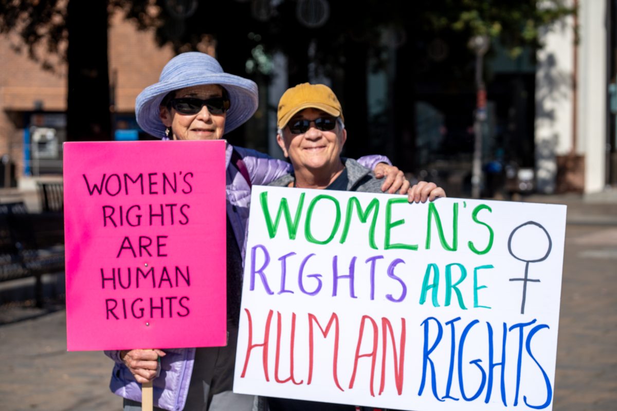 Friends Judi MArley, 77, and Loreene Romero, 64, proudly hold their handmade signs during the International Women’s Day march in Old Courthouse Square on Saturday, March 8, 2025 in Santa Rosa.  