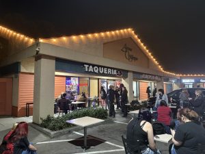 Showgoers hang out outside of Taqueria Mila between sets at a show on March 8, 2024.