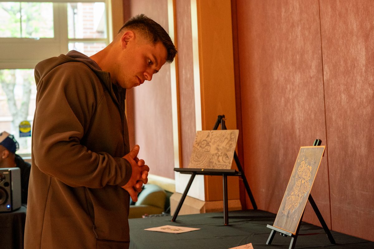 Santa Rosa Junior College student, Eddie Gugel studies the pieces of art on display in Bertolini Hall on Tuesday, April 15, 2025 in Santa Rosa.