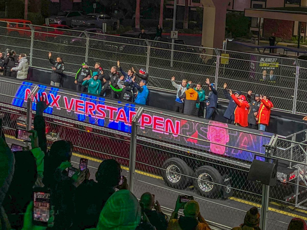 Max Verstappen and his crew wave at the supporting fans who are capturing the moment after placing fifth at the Las Vegas Grand Prix drivers parade on the Las Vegas strip in Nevada on Nov. 28. 