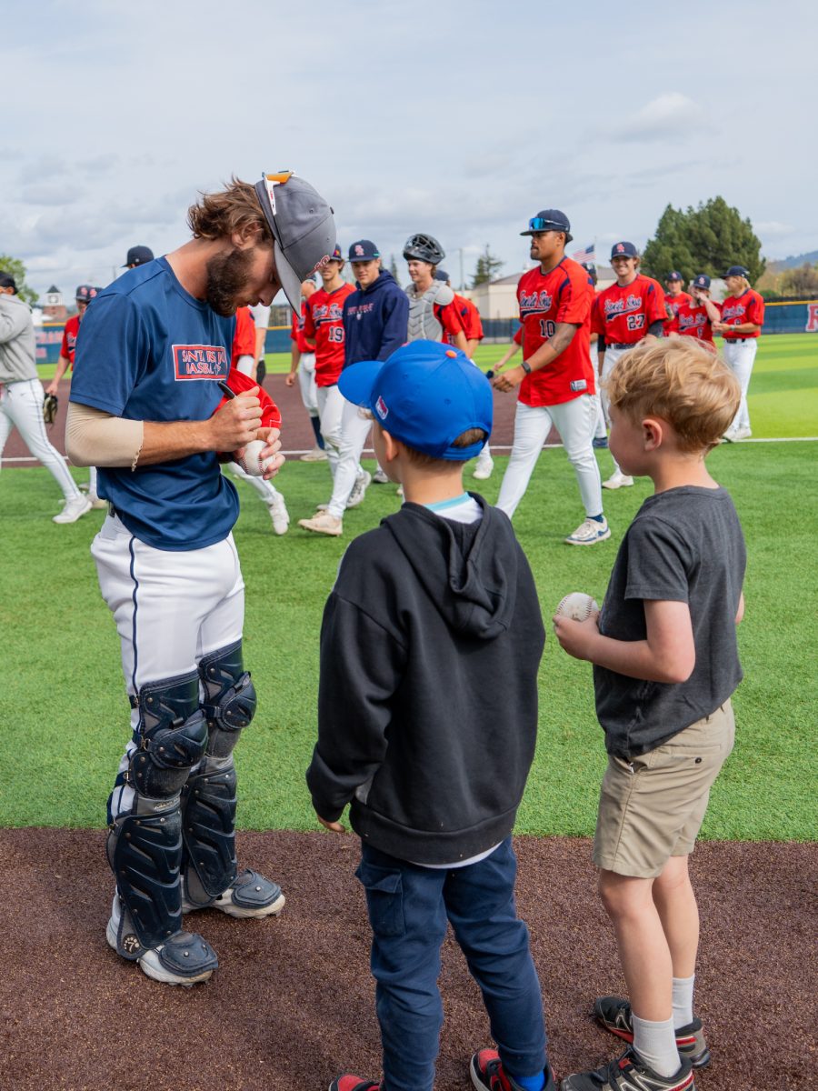 Sophomore catcher Cameron Duran signs a baseball for a young fan after the game against American River on Saturday March 29, 2025 in Santa Rosa.
