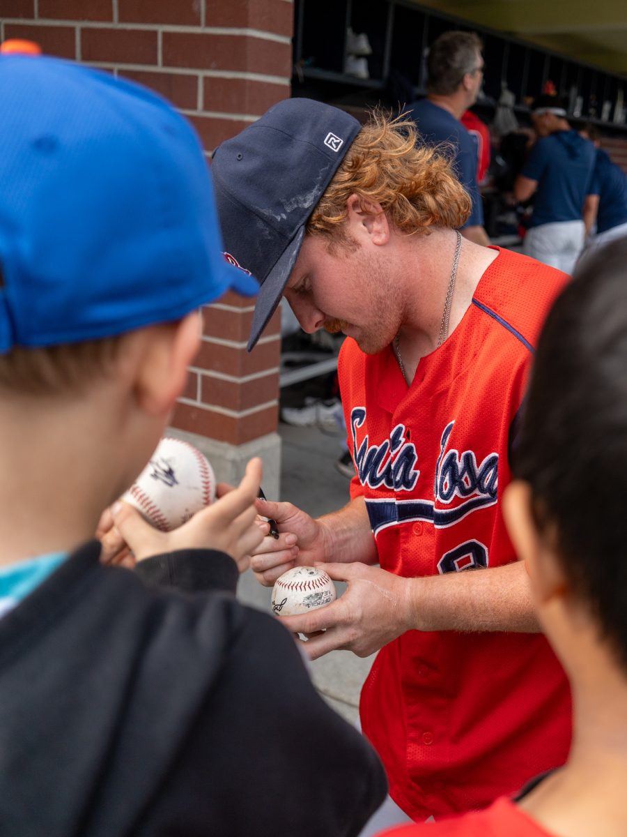 Sophomore second baseman Joe Brown autopgrahs baseballs near the dugout after the team's win against American River on Saturday March 29, 2025 in Santa Rosa.