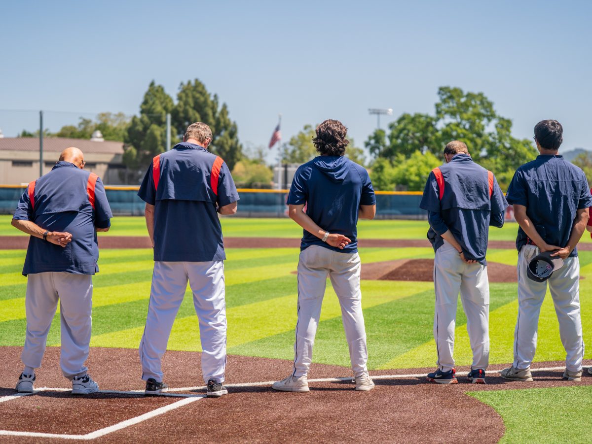 The SRJC baseball coaching staff stand solemnly during the national anthem ahead of the first game against American River for the the 3C2A Baseball Regionals on Friday, May 2, 2025 at home.