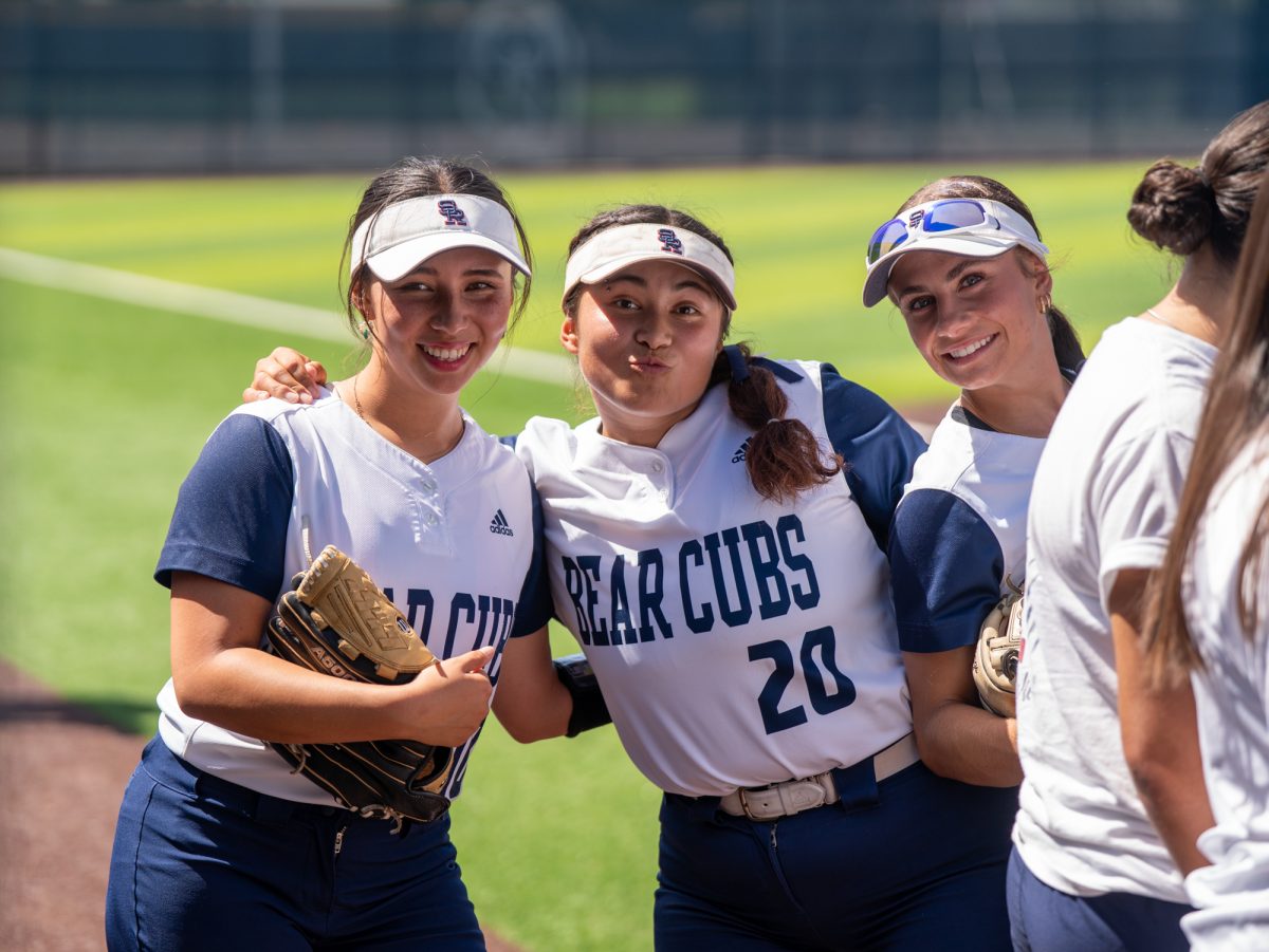 From left to right, sophomores Kayla Ling, Gabby Schenone and Kali Garcia huddle together before the lineup is announced for Sophomore Day on Tuesday, April 22 at home.